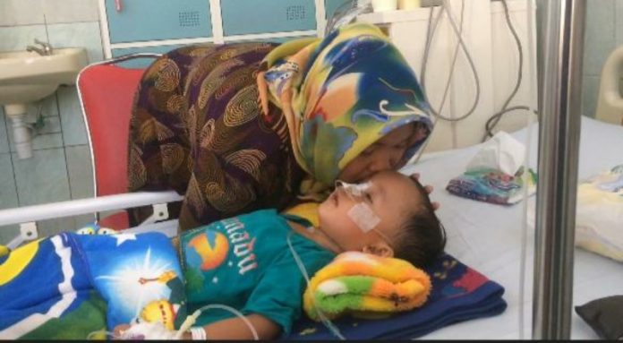 Widatur Rohimah mendampingi anaknya, M. Radika Aditya di ruang perawatan anak RSUD Dr Soedarsono, Kota Pasuruan. Selasa, (25/6/2019)